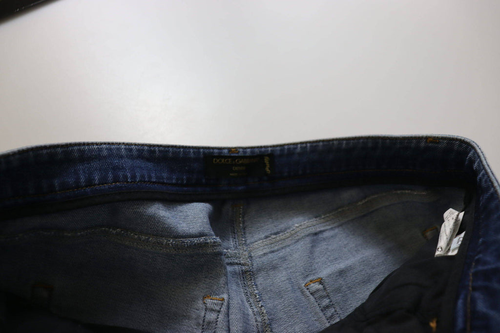 Jeans skinny en denim bleu lavé Dolce & Gabbana avec taille basse et coupe ajustée, visibles sur la photo.