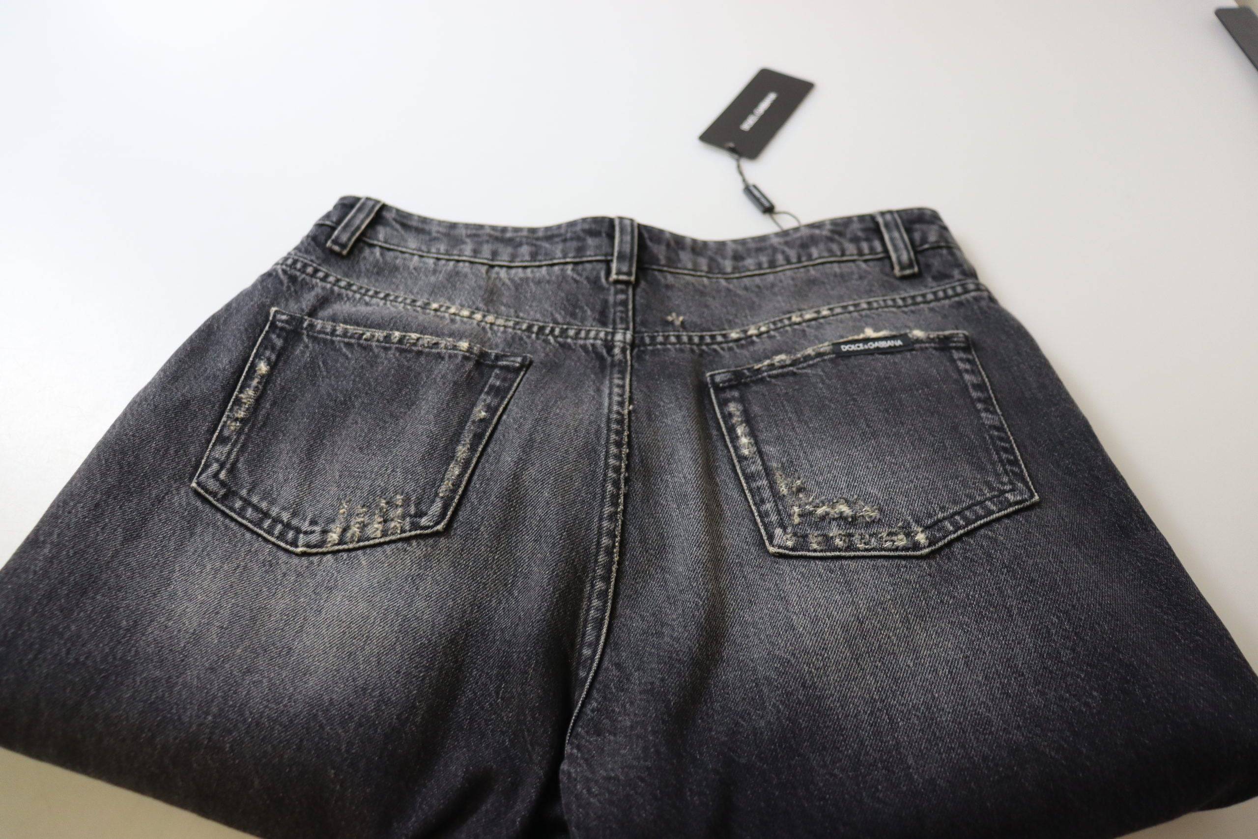Jeans en denim noir délavé et déchiré à taille haute de Dolce & Gabbana, style tendance et décontracté.