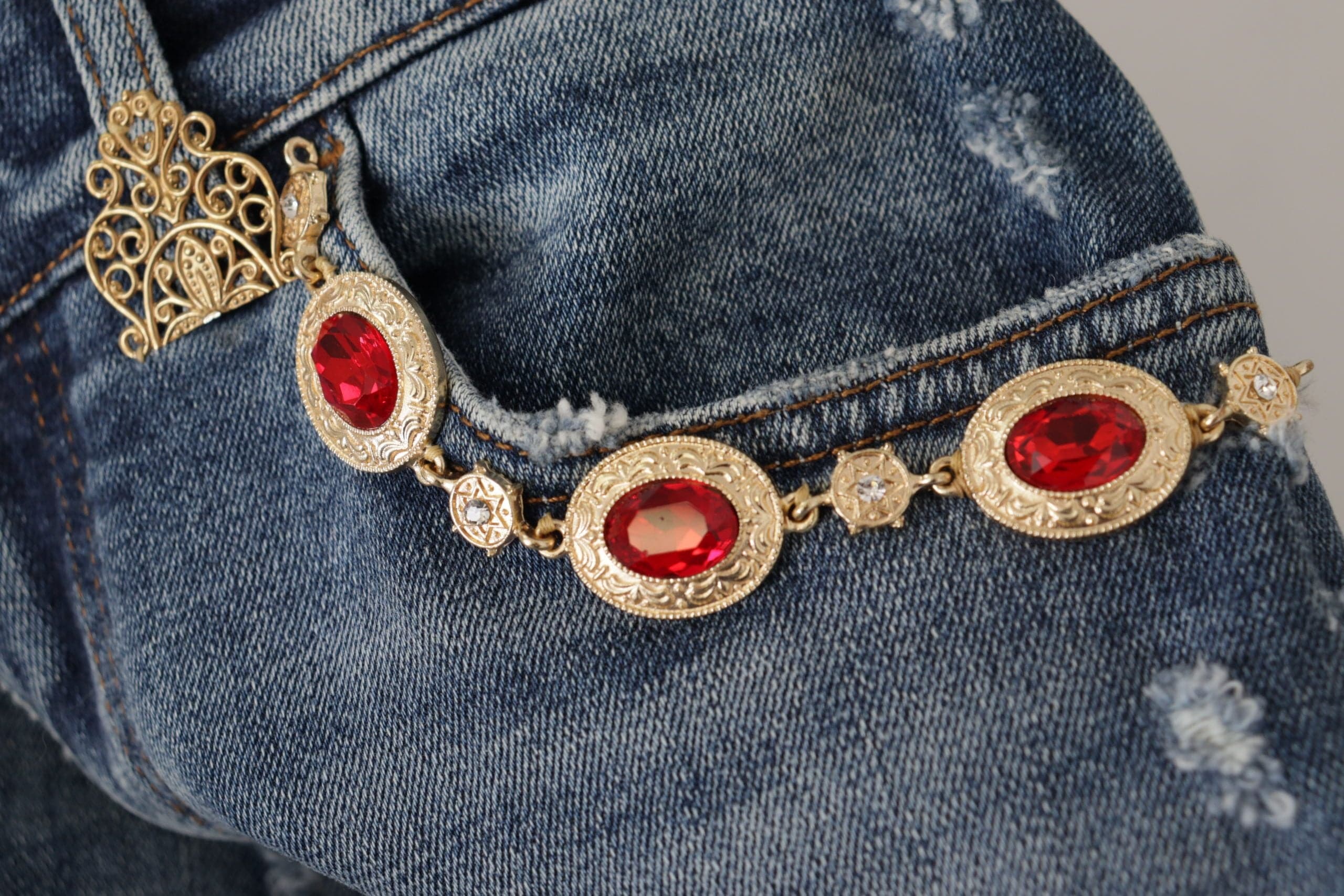 Pantalon en jean bleu Dolce & Gabbana avec ornements en cristal, tissu denim élégant et détails raffinés.