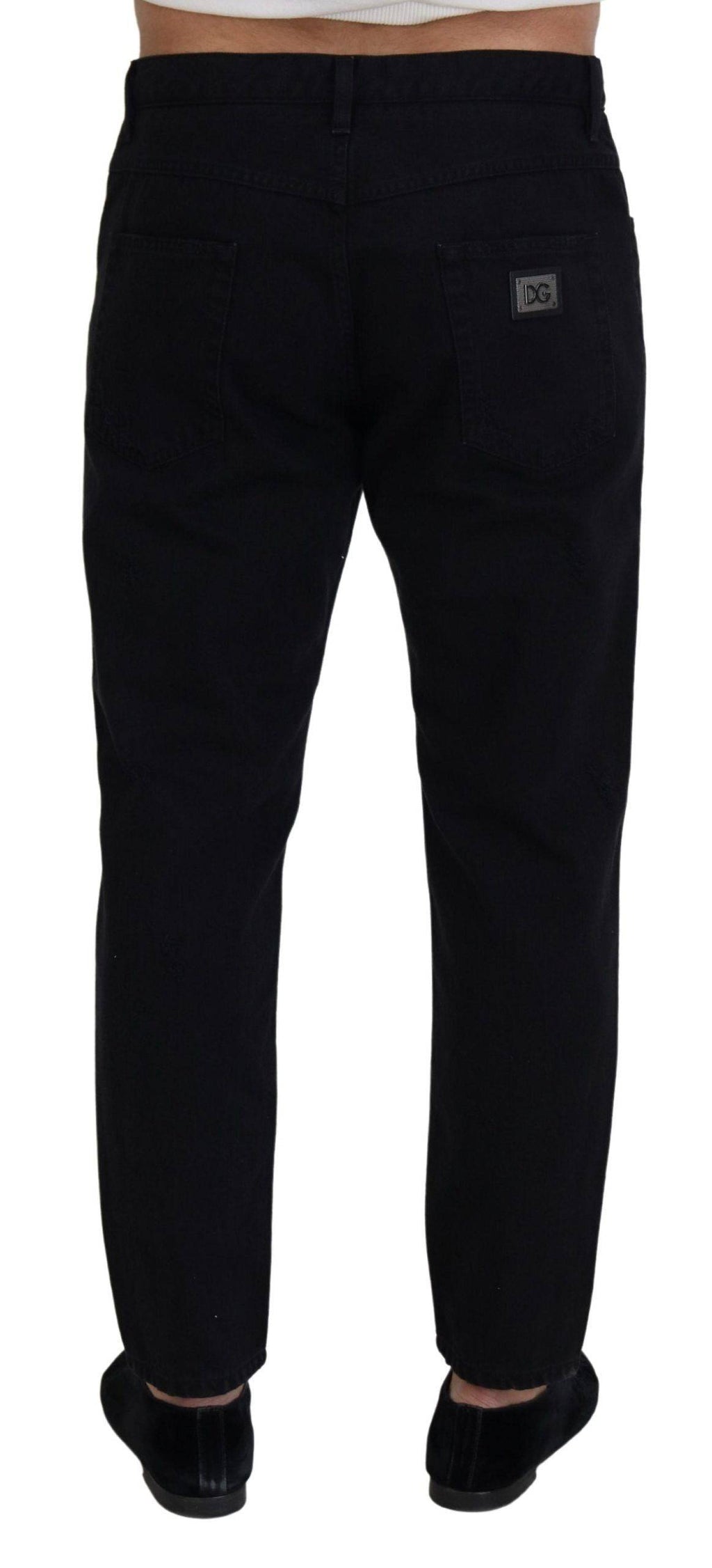 Jeans en coton noir Dolce & Gabbana, coupe décontractée, avec déchirures et style loose, visibles sur l'image.