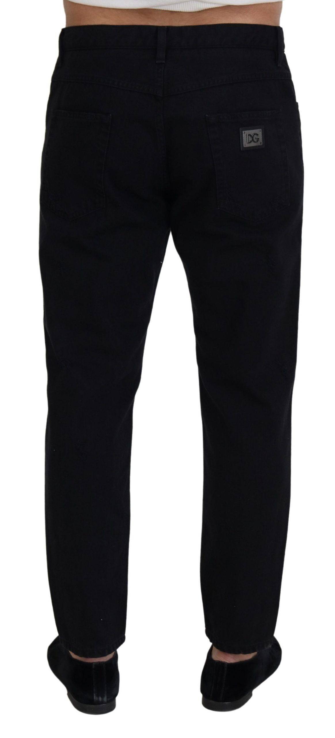 Jeans en coton noir Dolce & Gabbana, coupe décontractée, avec déchirures et style loose, visibles sur l'image.