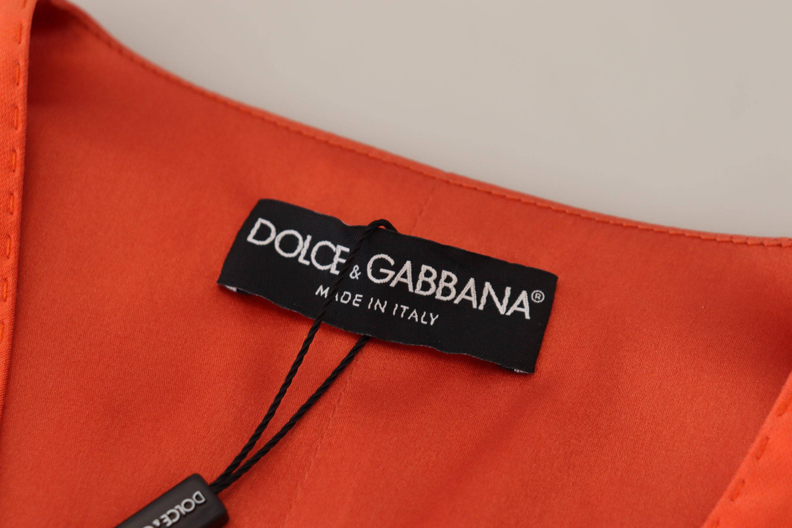 Gilet sans manches orange Dolce & Gabbana taille courte, cropped, en tissu léger, porté sur un mannequin blanc.
