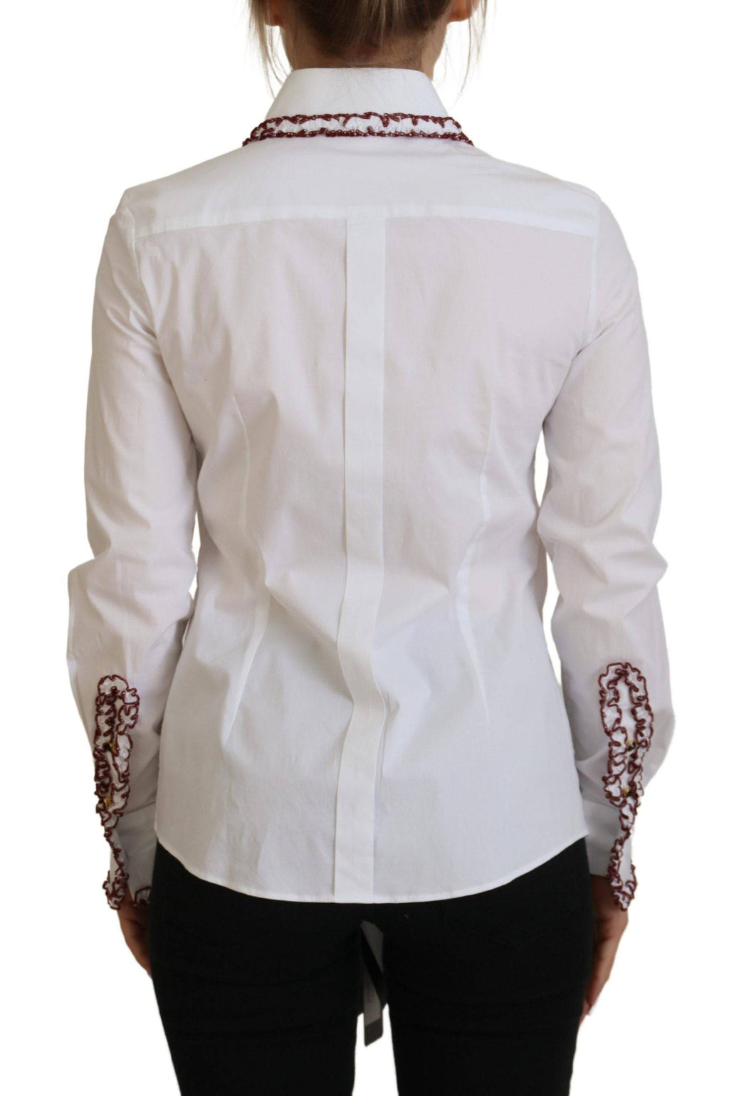 Haut blanc en dentelle Dolce & Gabbana avec manches longues et col à volants, élégant et féminin.