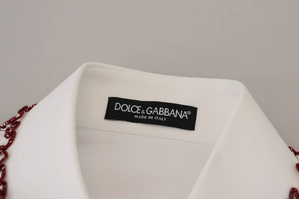Chemisier blanc en dentelle Dolce & Gabbana avec manches longues, col à volants et détails élégants.