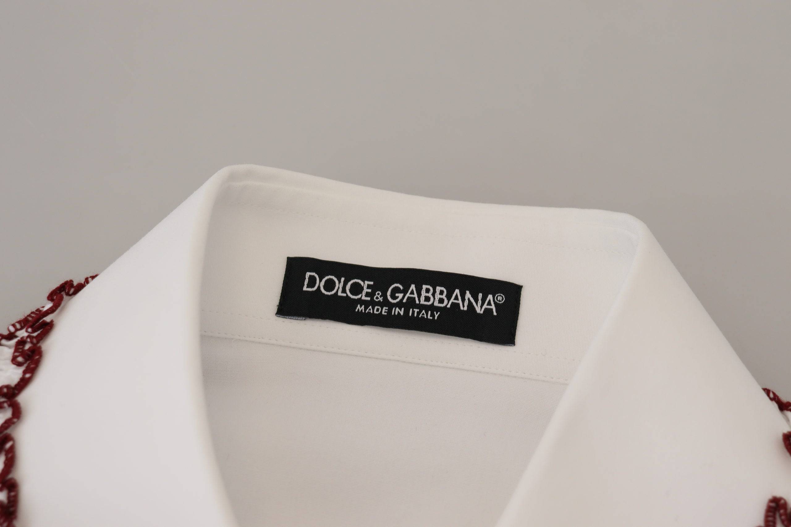 Chemisier blanc en dentelle Dolce & Gabbana avec manches longues, col à volants et détails élégants.