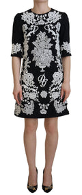 Robe Dolce & Gabbana noire à manches mi-longues et bordure en dentelle, coupe évasée élégante.