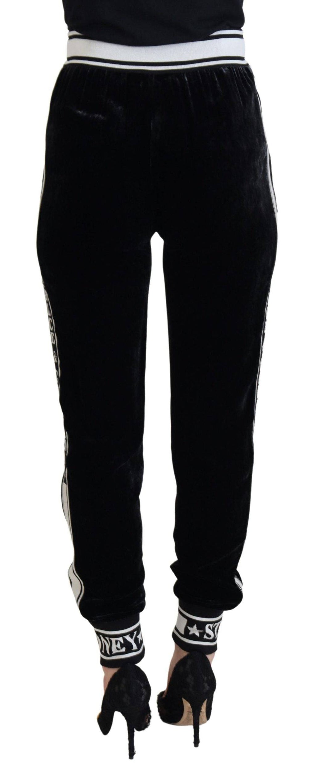 Pantalon en velours noir Dolce & Gabbana avec logo DG, coupe élégante et détails sophistiqués, porté sur un mannequin.