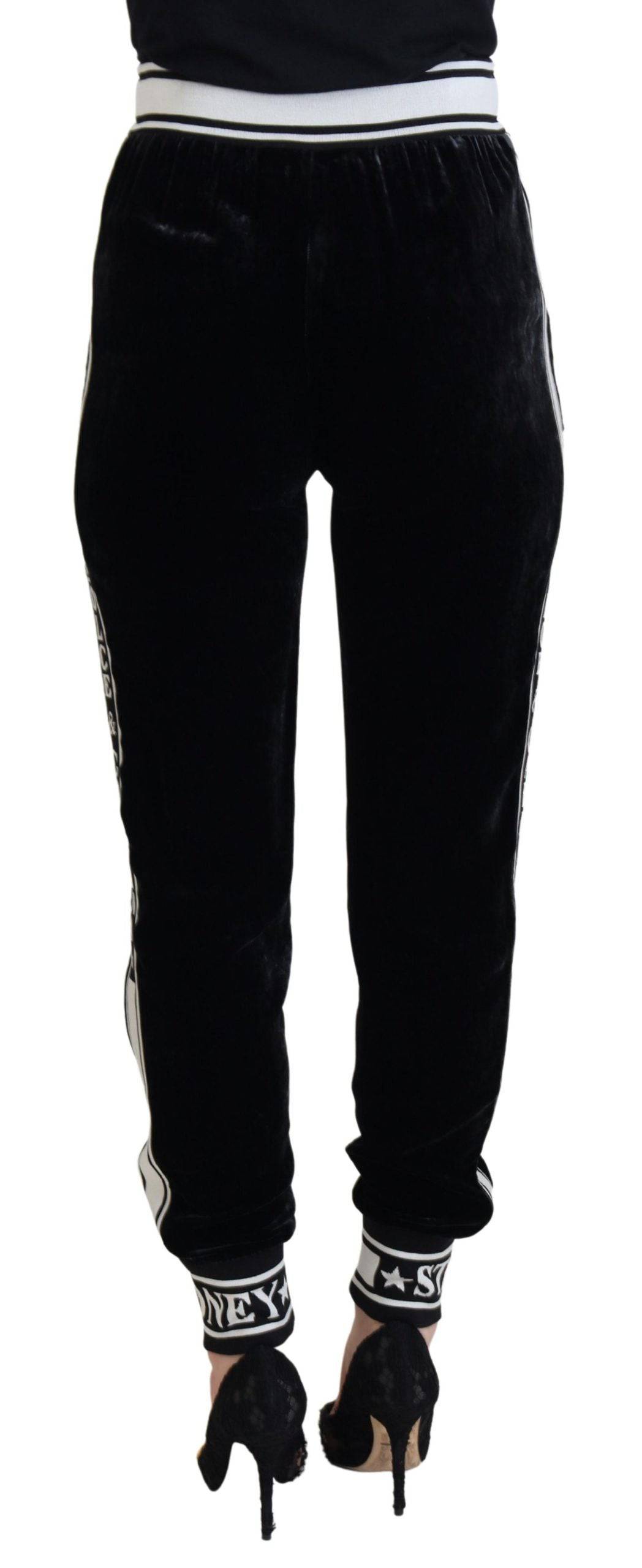 Pantalon en velours noir Dolce & Gabbana avec logo DG, coupe élégante et détails sophistiqués, porté sur un mannequin.
