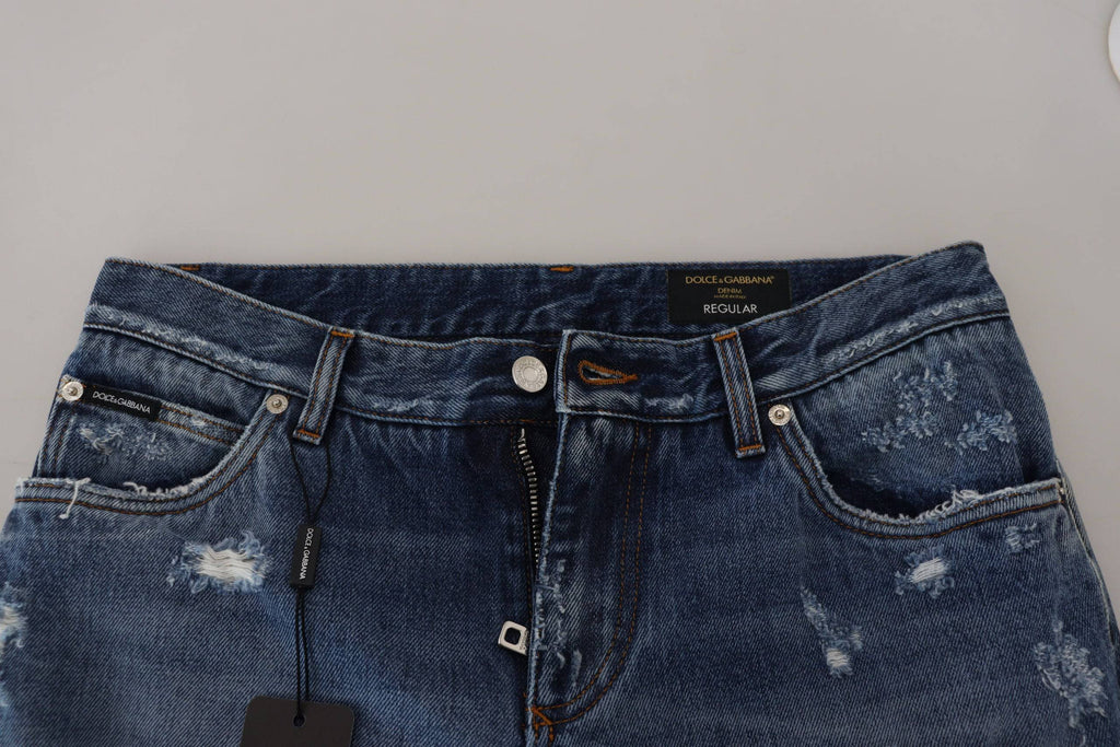 Jeans en denim bleu pour homme de Dolce & Gabbana, coton tacheté avec détails usés et déchirés.
