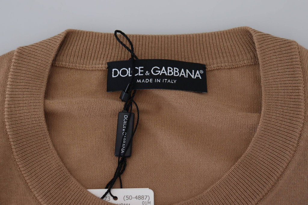 Pull-over en cachemire beige Dolce & Gabbana avec logo couronne, doux et élégant, visible en détail dans l'image.
