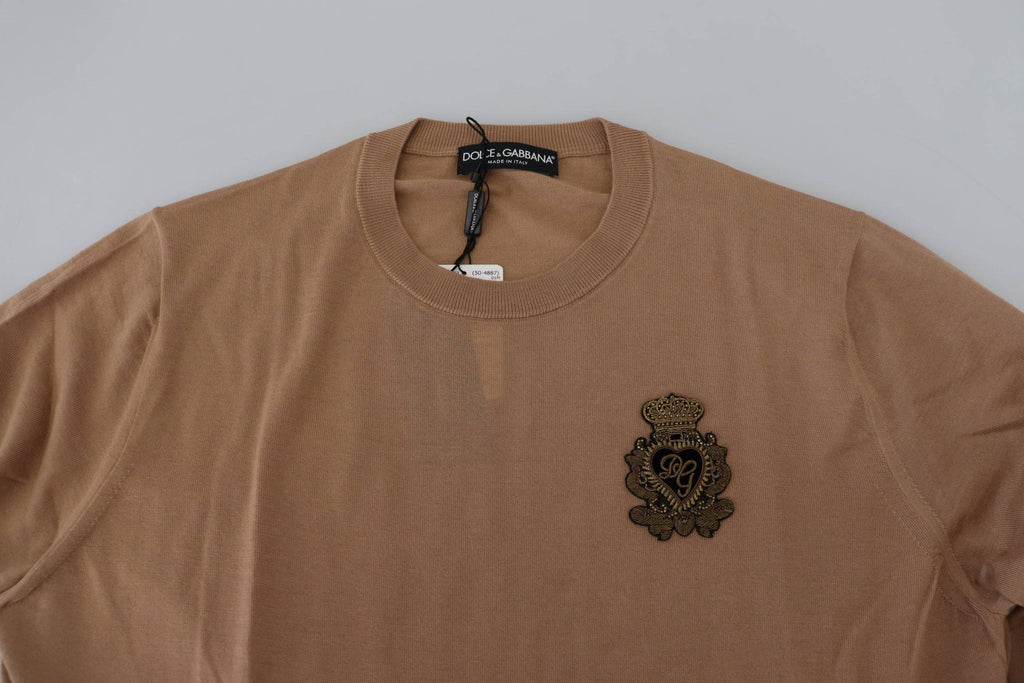 Pull-over en cachemire beige Dolce & Gabbana avec logo couronne, doux, élégant et confortable, visible en détail.