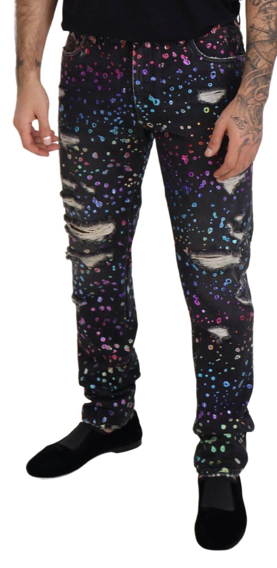 Jeans en denim déchiré noir à imprimé multicolore de Dolce & Gabbana, style tendance et détails déchirés visibles.
