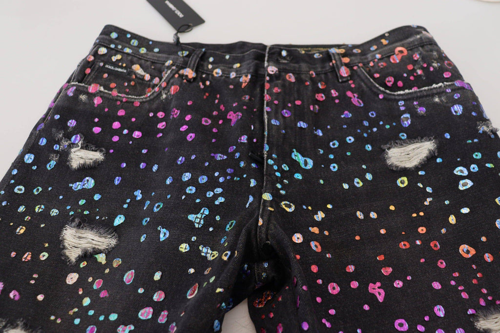 Jean en denim déchiré Dolce & Gabbana à motif multicolore noir et blanc, avec détails usés et style décontracté.