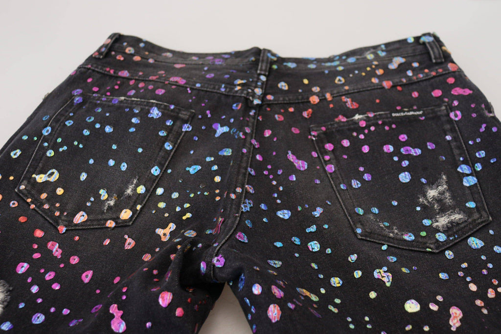 Jeans déchirés en denim noir à imprimé multicolore de Dolce & Gabbana, style tendance et détails décontractés.