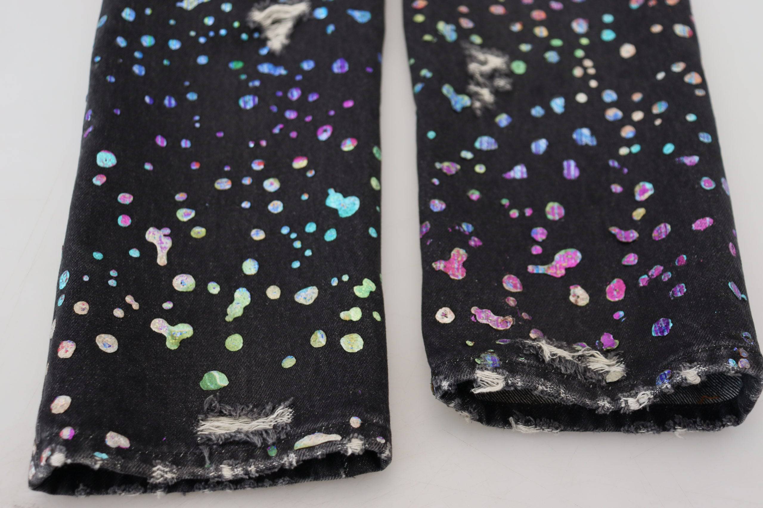 Jeans en denim déchiré noir à imprimé multicolore de Dolce & Gabbana, style tattered et tendance.