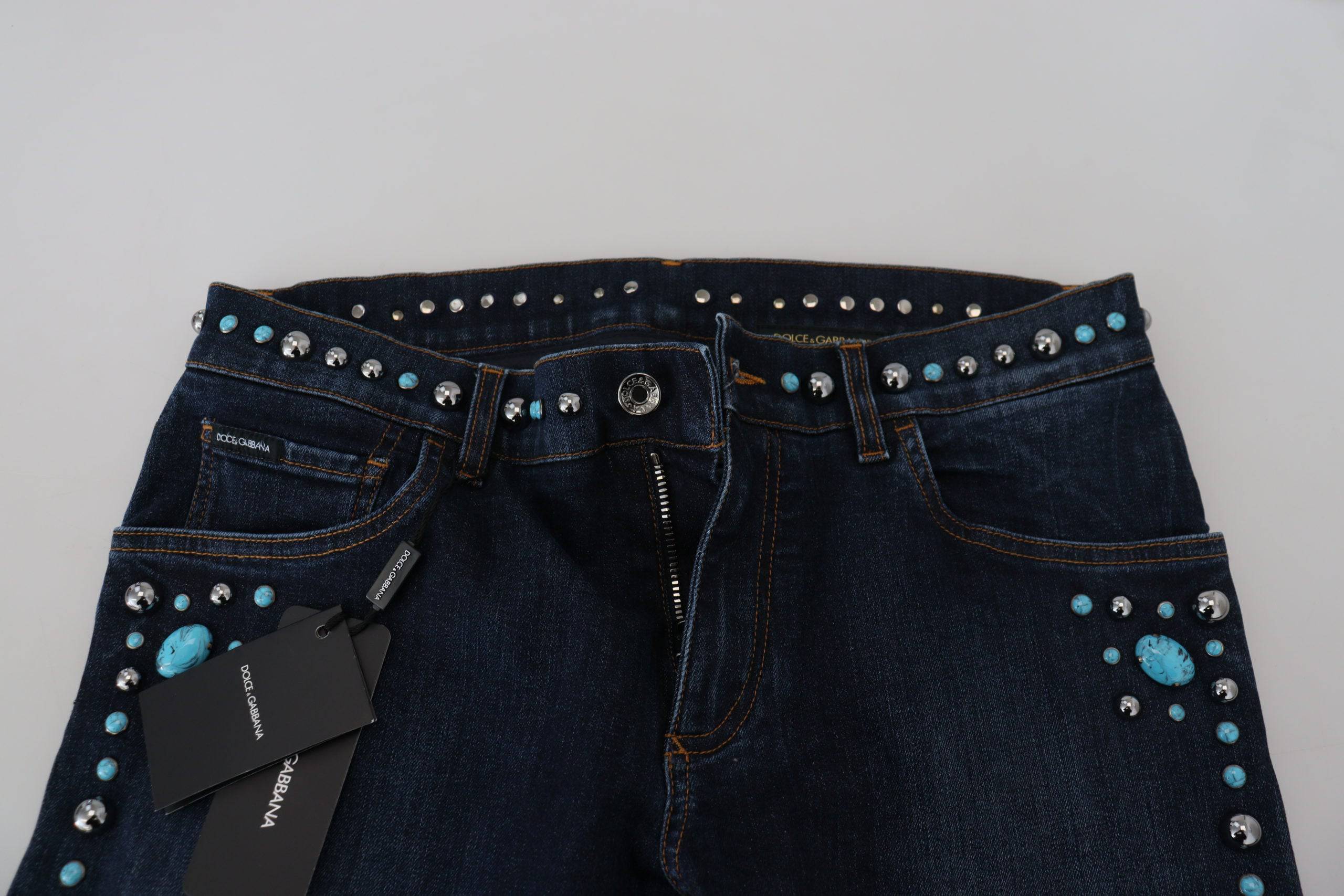 Jeans en denim bleu Dolce & Gabbana, taille basse, avec des studs en coton, style décontracté et tendance.