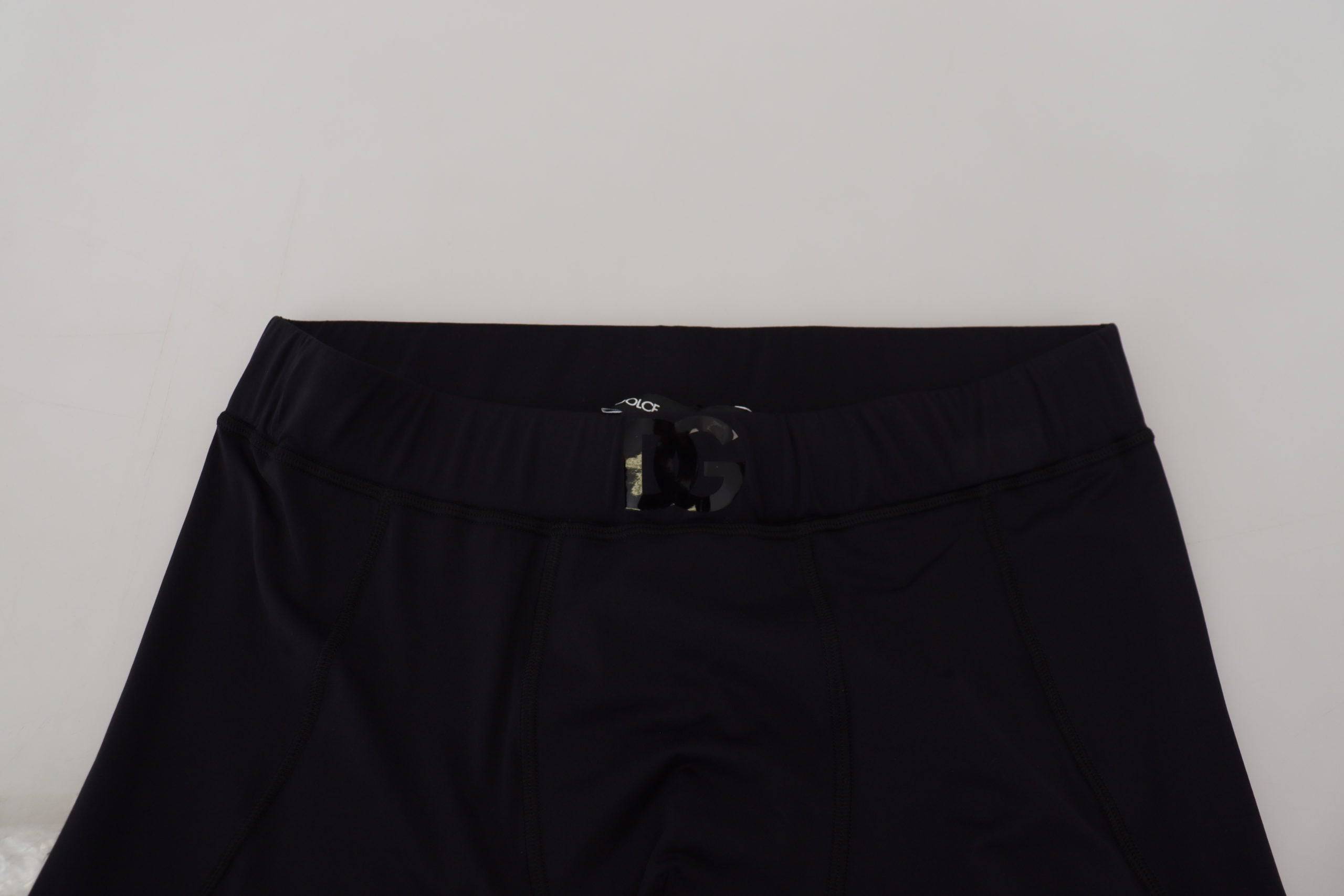 Pantalons slim en nylon noir Dolce & Gabbana, coupe ajustée et stretch, visibles en détail dans l'image.