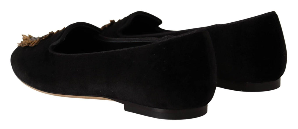 Chaussures plates Dolce & Gabbana en cuir noir avec patch cœur sacré DG, slip-on élégantes et confortables.