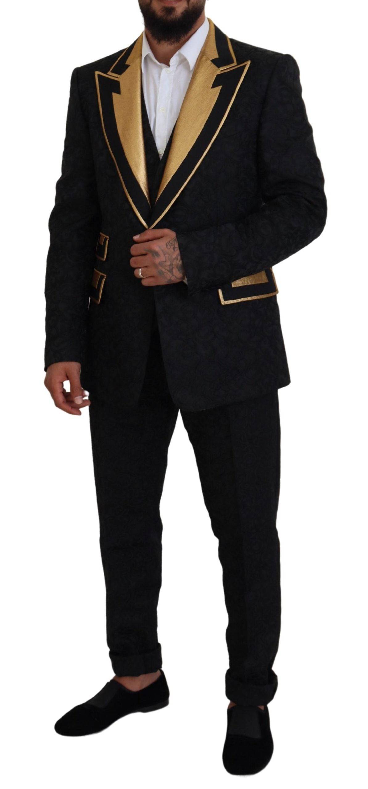 Costume smoking noir et or Dolce & Gabbana, coupe slim, avec détails sophistiqués et tissu élégant.