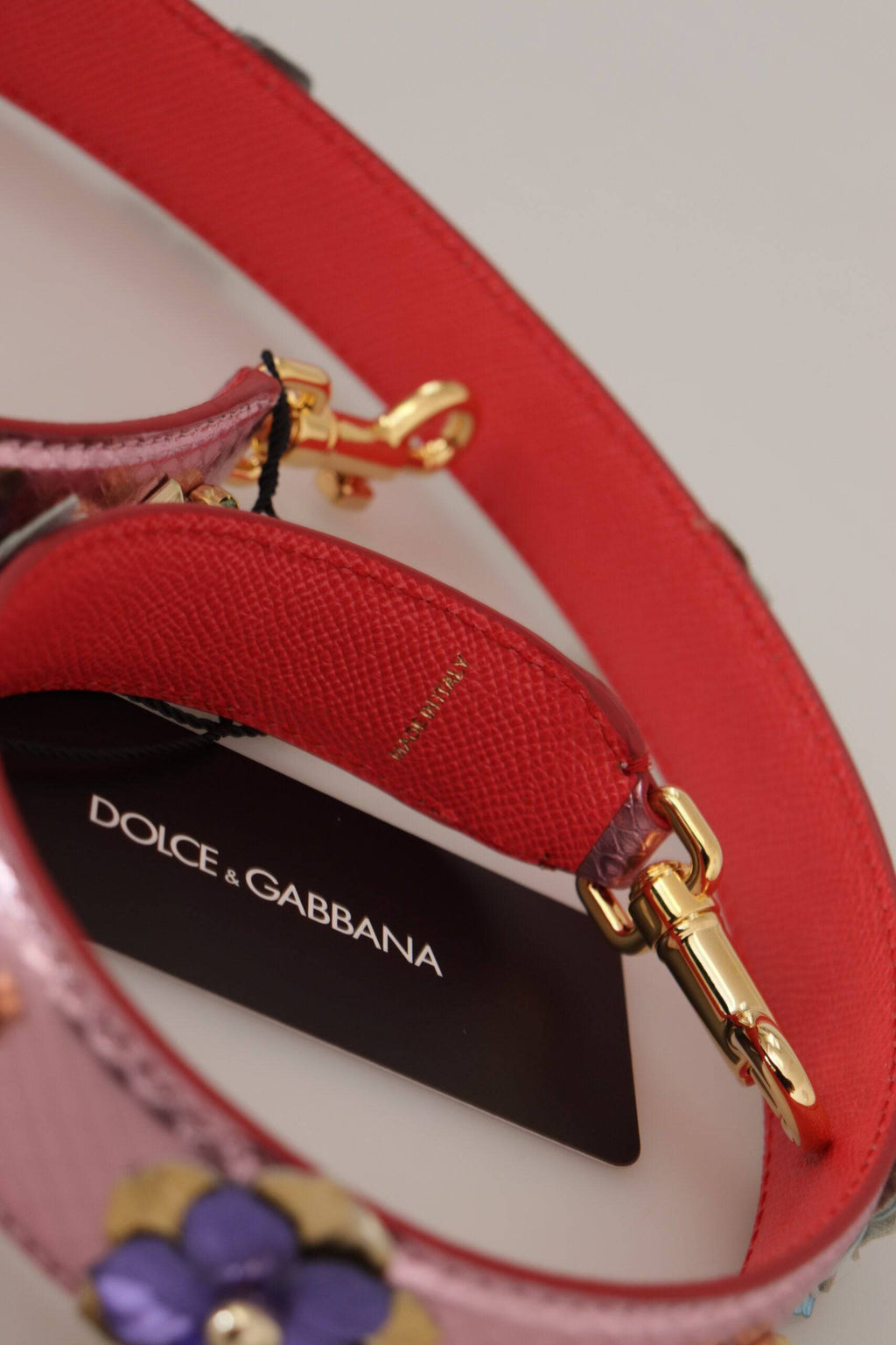 Sangle d'épaule en cuir métallique rose avec studs de la marque Dolce & Gabbana, vue en gros plan.