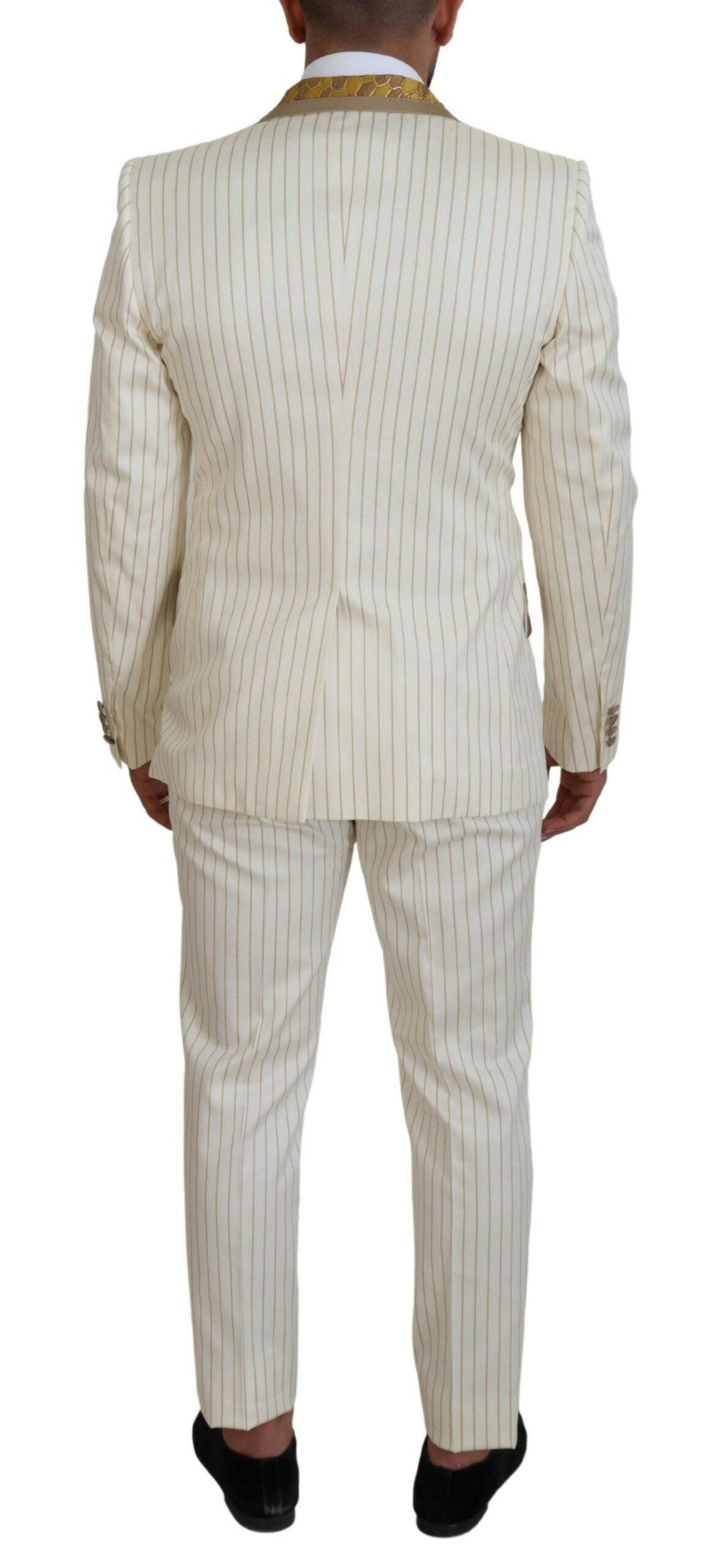 Costume de smoking slim fit Dolce & Gabbana blanc avec rayures or, élégant et sophistiqué, porté sur un mannequin.