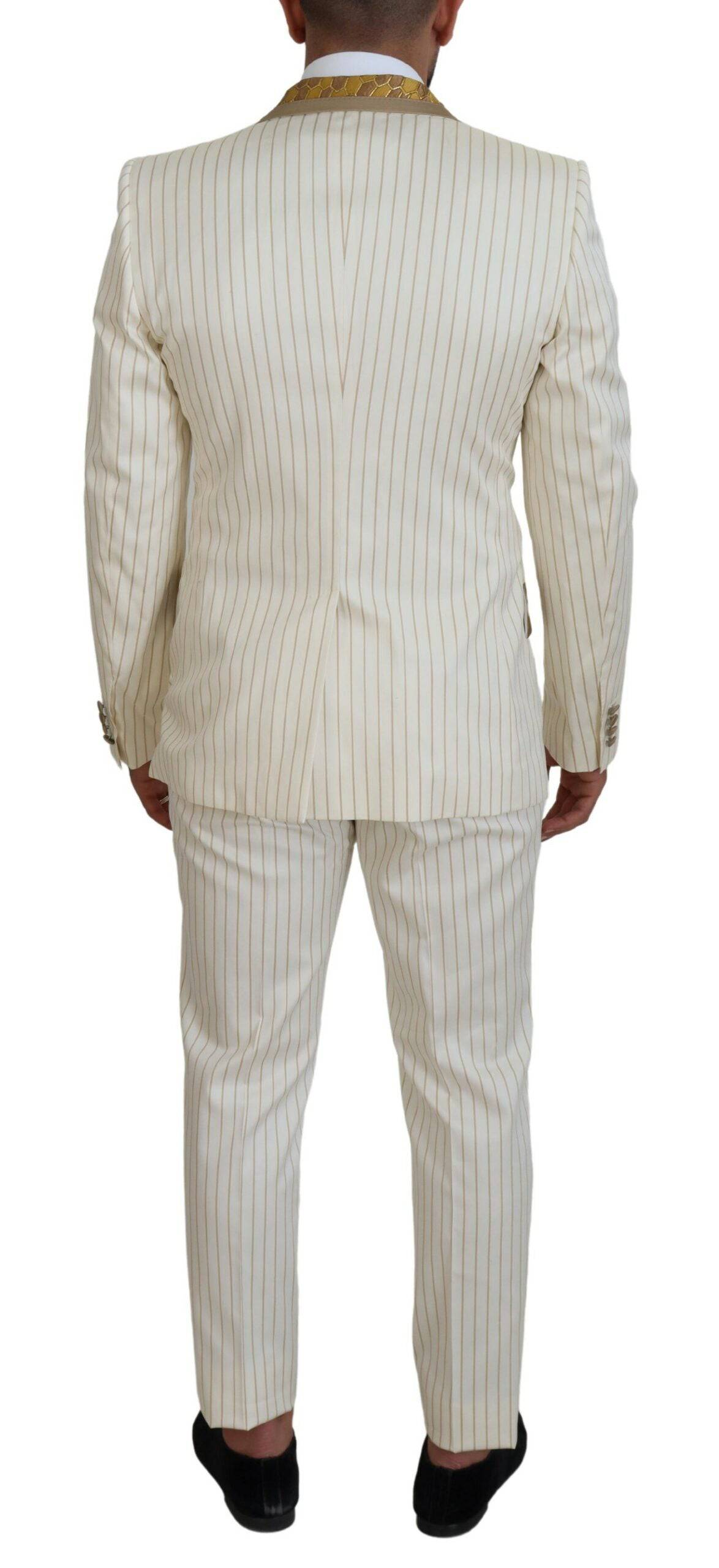Costume de smoking slim fit Dolce & Gabbana blanc avec rayures or, élégant et sophistiqué, porté sur un mannequin.
