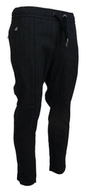 Pantalons en coton gris Dolce & Gabbana, coupe tapered, visibles en gros plan sur l'image.