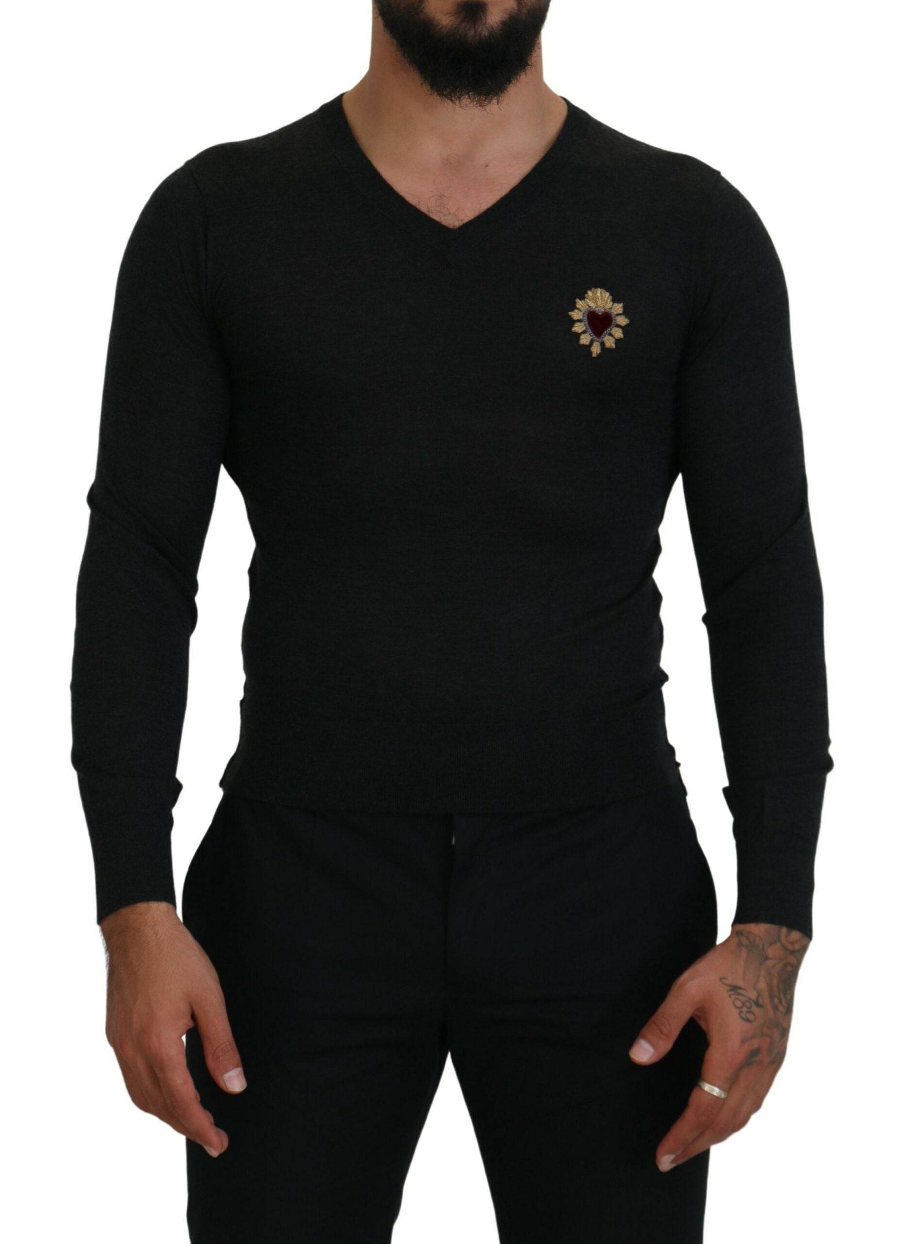 Pull en cachemire gris Dolce & Gabbana avec col en V et motif cœur doré visible sur l'image.