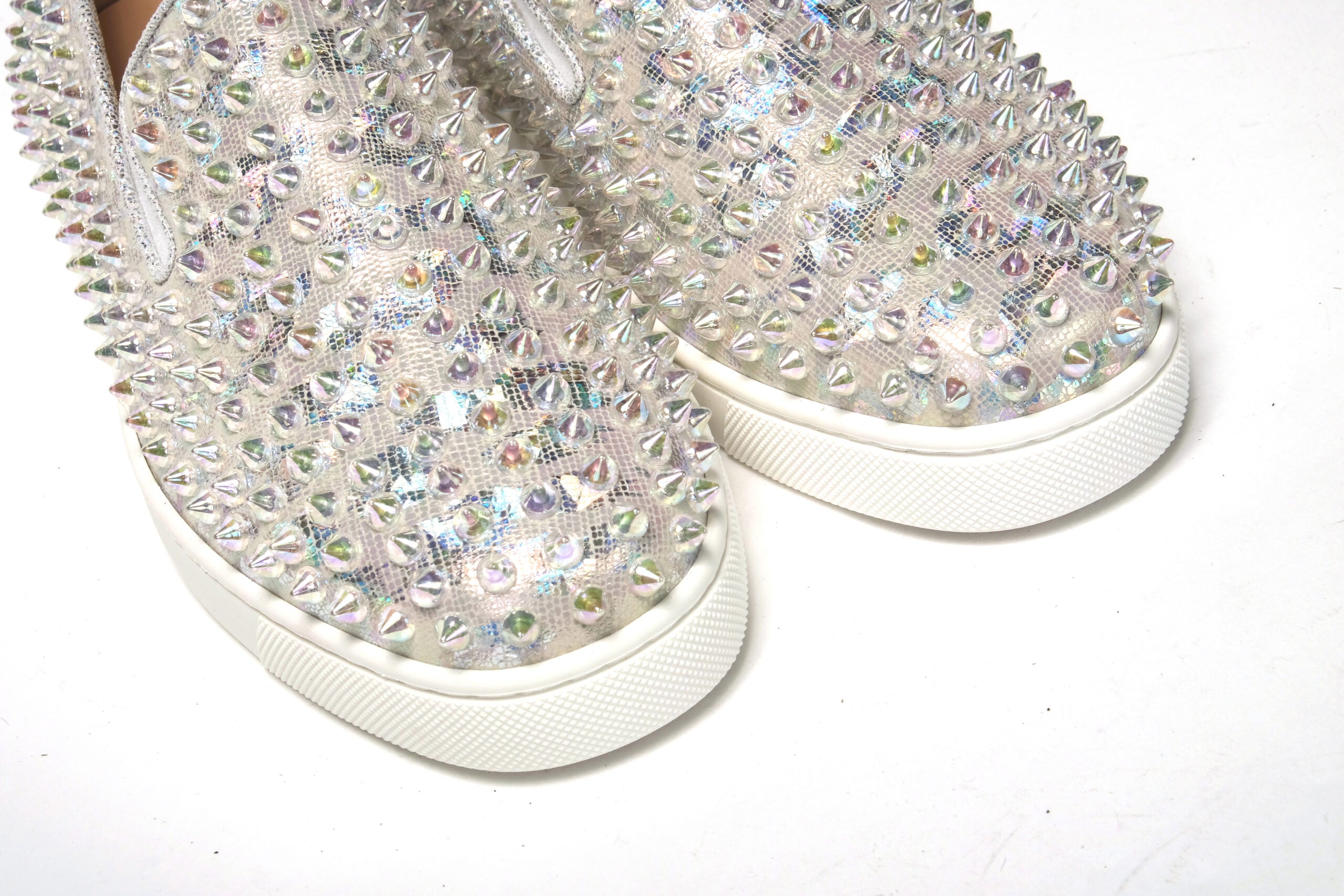 Chaussure sneaker plate Christian Louboutin blanche avec détails transparents et motif bateau pour femme, silhouette plate et élégante.