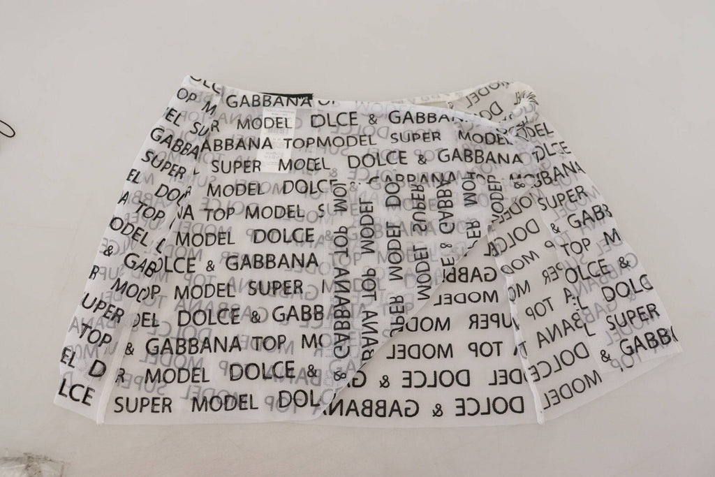 Jupe courte blanche en dentelle à logo transparent de Dolce & Gabbana, coupe trapèze et tissu léger.