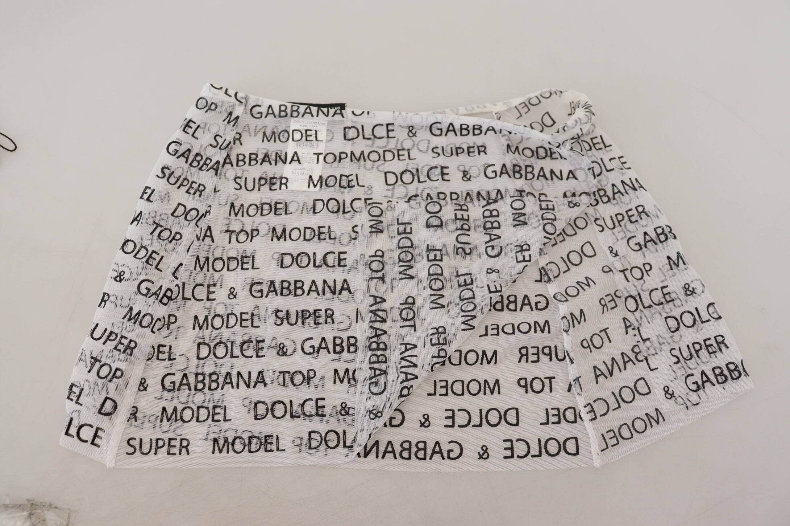 Jupe courte blanche en dentelle à logo transparent de Dolce & Gabbana, coupe trapèze et tissu léger.