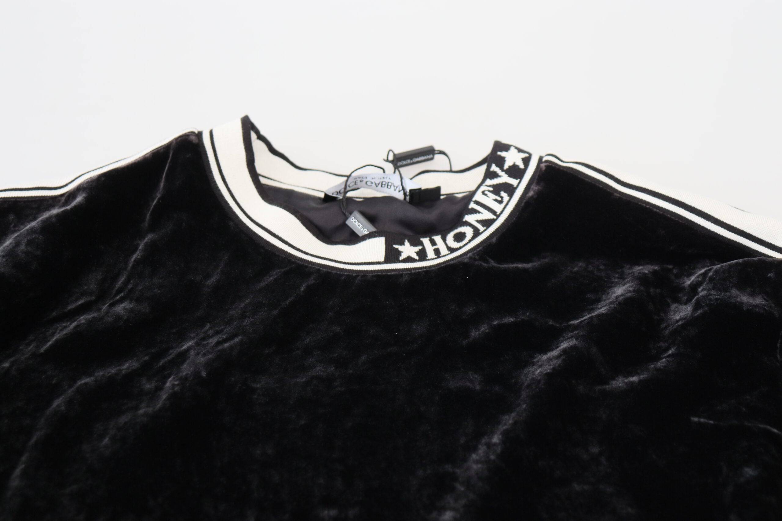 Pull noir en velours Dolce & Gabbana avec col ras du cou, détail élégant et texture douce visible sur l'image.