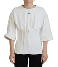 Haut blanc Dolce & Gabbana en coton extensible, corset ajusté, porté comme t-shirt, visible avec détails de couture.