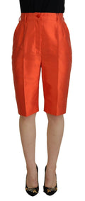 Pantalon court en soie orange à taille haute de Dolce & Gabbana, coupe élégante et tissu fluide visible dans l'image.