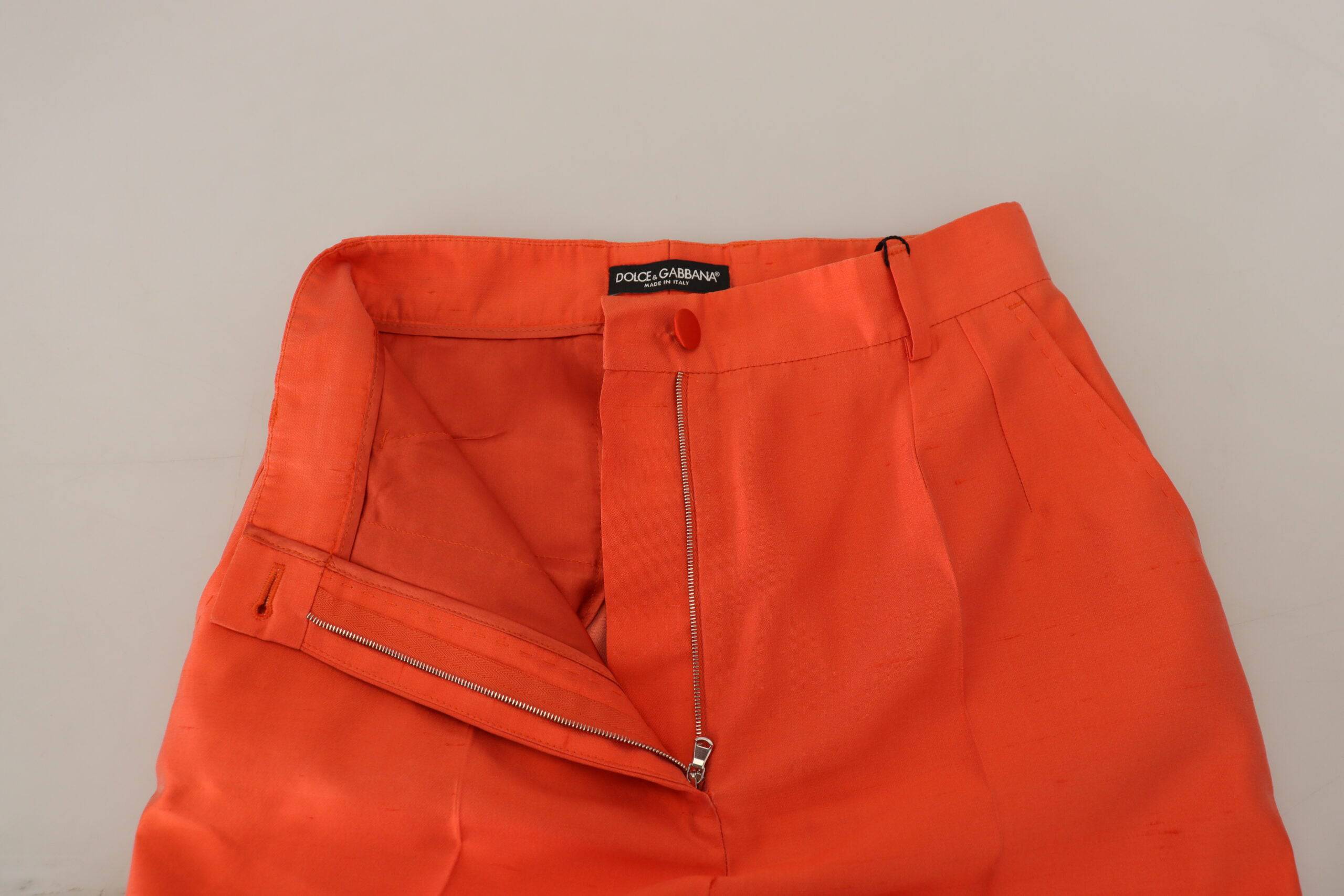 Pantalon court en soie orange à taille haute de Dolce & Gabbana, mode chic et élégante, visible sur l’image.