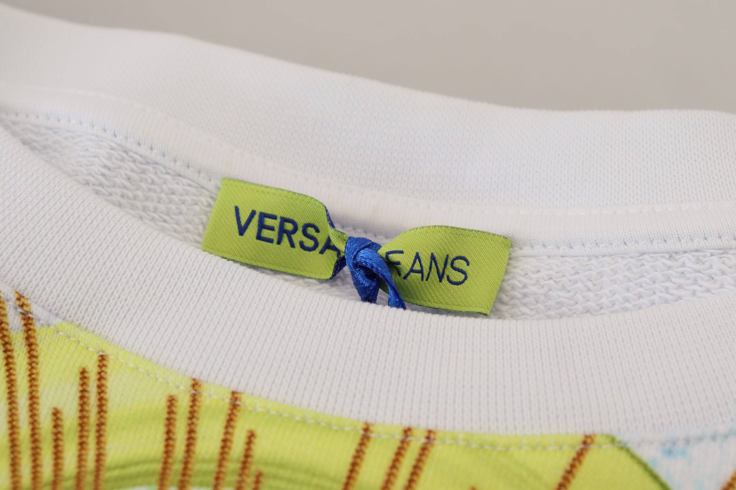 Pull à manches longues Versace Jeans blanc avec imprimé graphique, style moderne et tendance, visible sur le produit.