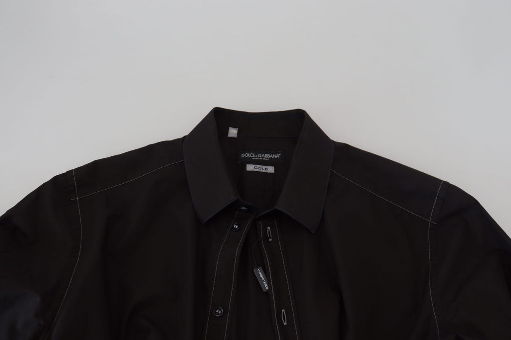 Chemise longue en coton noir Dolce & Gabbana avec col et manche longue, orné de détails dorés.