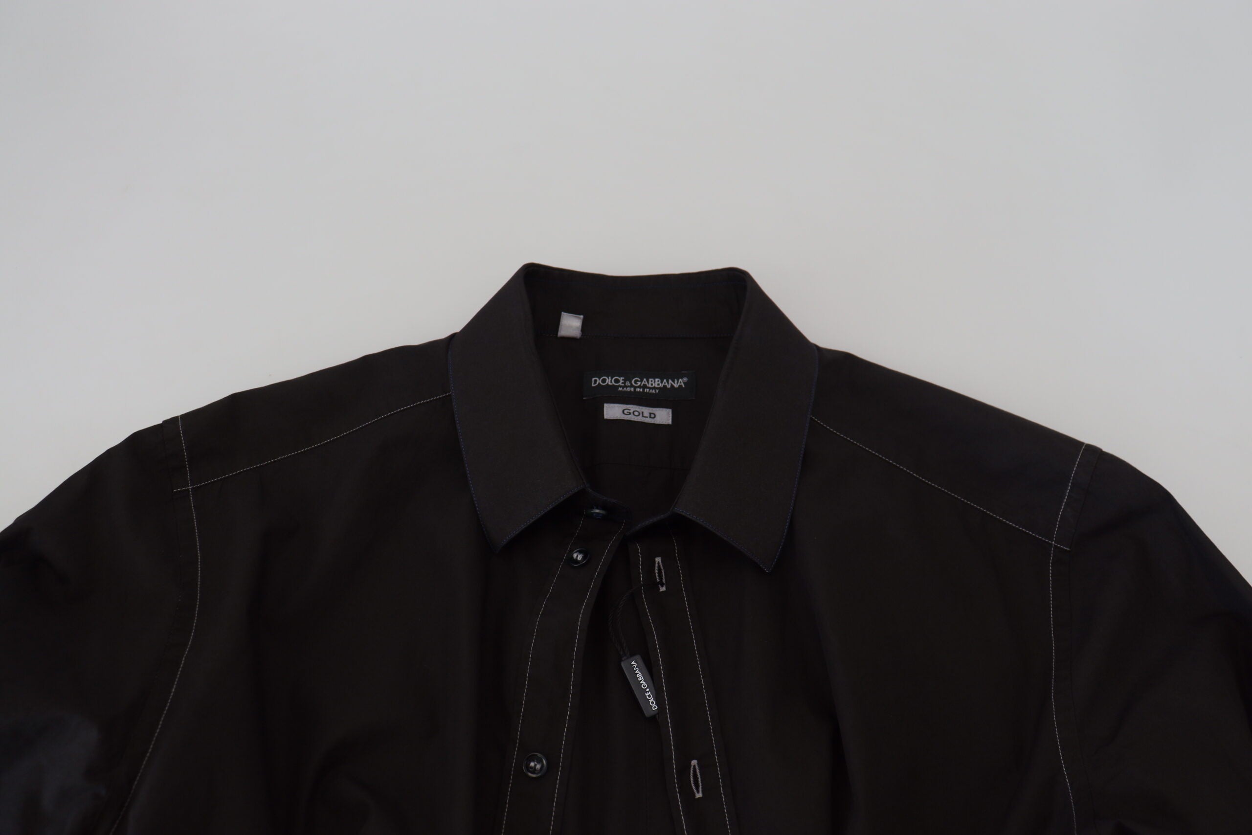 Chemise longue en coton noir Dolce & Gabbana avec col et manche longue, orné de détails dorés.