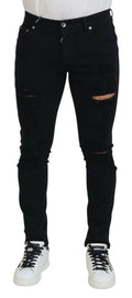 Jeans en denim noir Dolce & Gabbana, coupe slim, déchirés, en coton, affichant un style moderne et tendance.