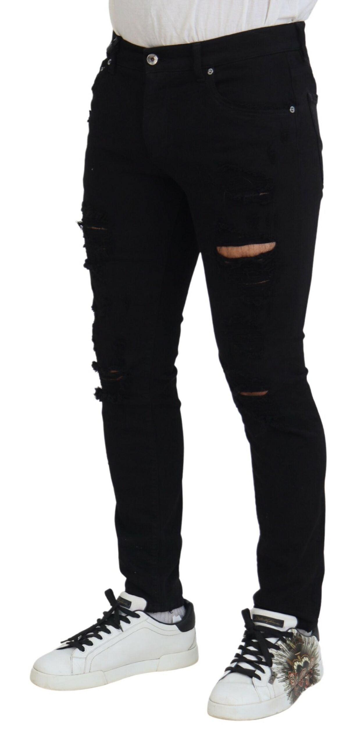 Jeans en denim noir Dolce & Gabbana, coupe slim, déchirés, en coton, affichés sur un mannequin dans l'image.