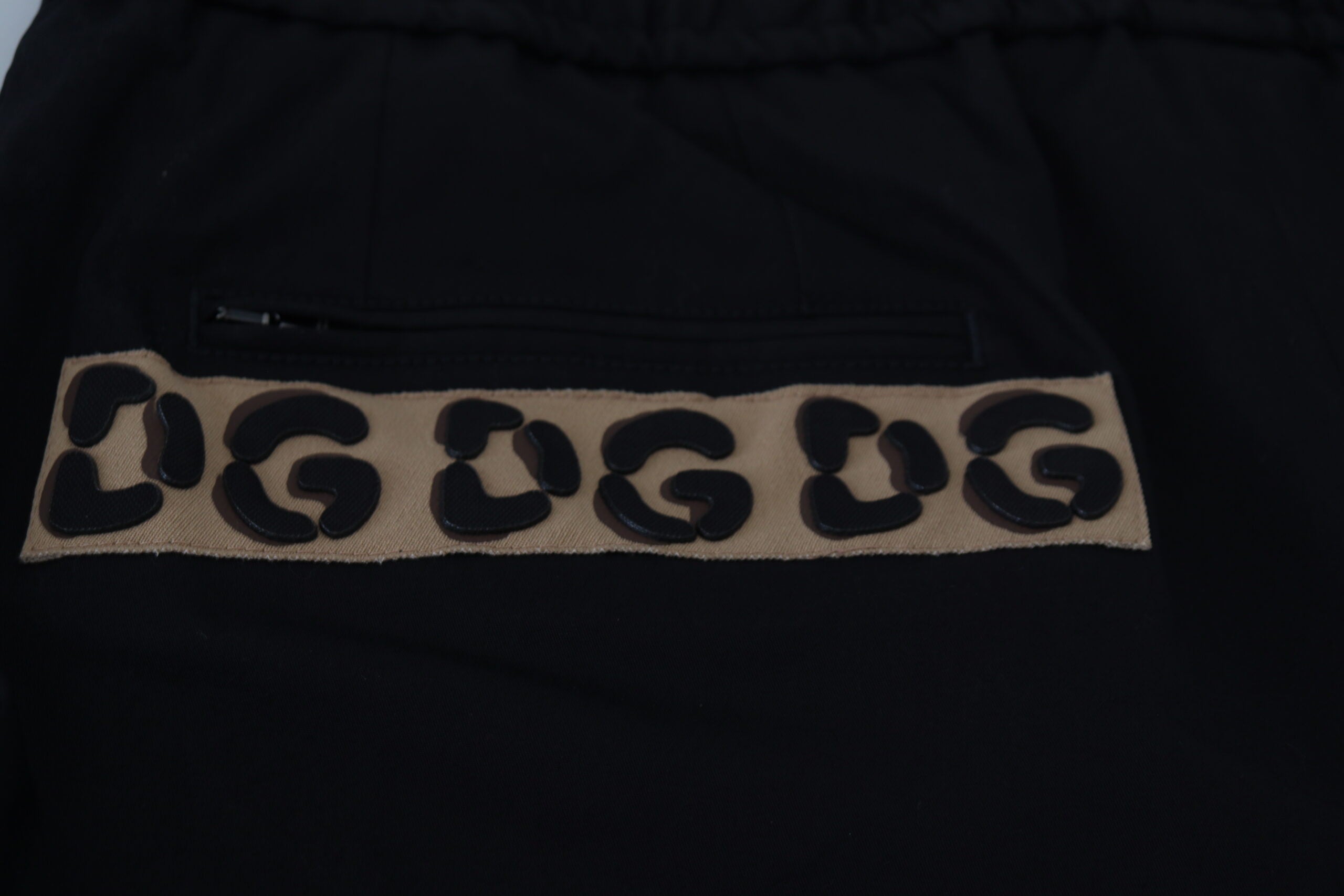 Pantalon court en coton noir Dolce & Gabbana avec taille élastique et logo DG visible, style décontracté et moderne.