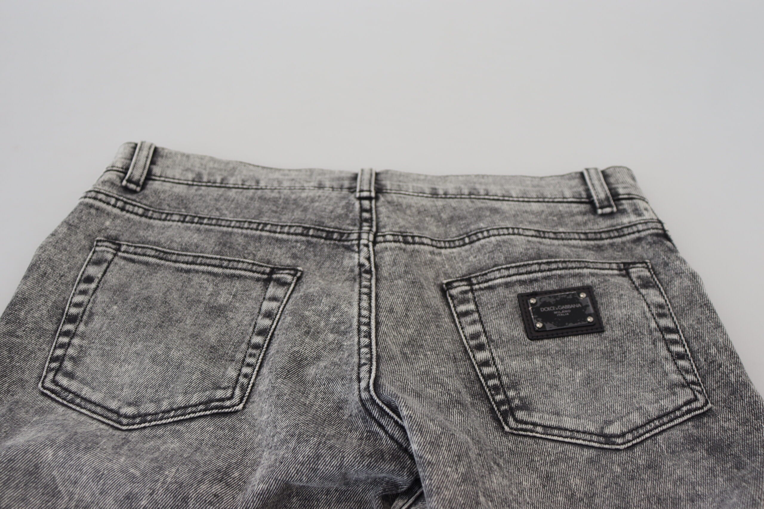 Jeans slim en denim gris délavé Dolce & Gabbana pour homme, coupe ajustée et détails modernes visibles sur l'image.
