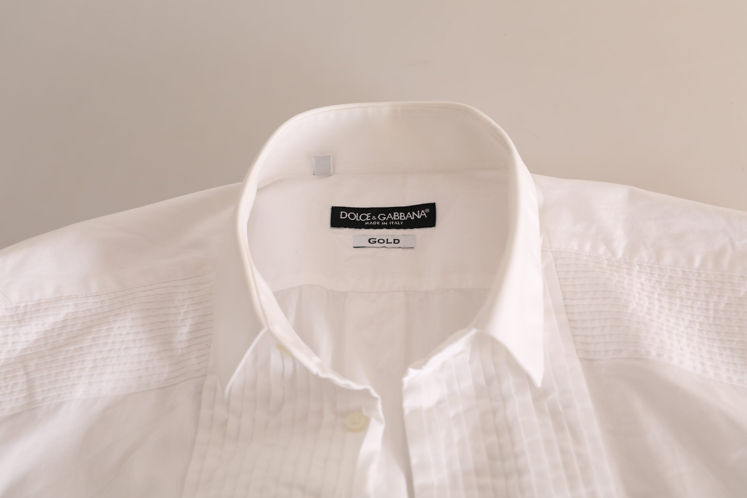 Chemise blanche en coton Dolce & Gabbana pour costume formel avec détails en or, vue de face sur une robe de soirée élégante.