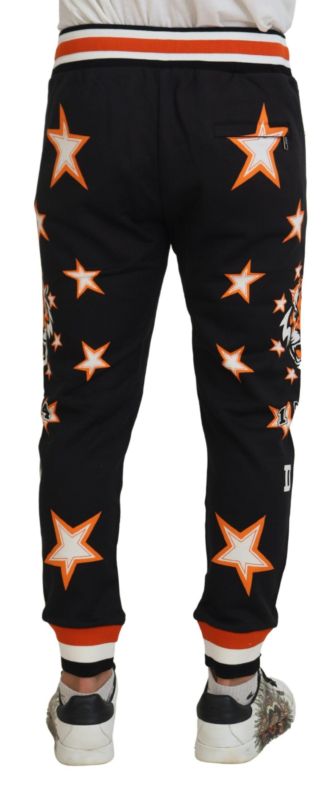 Pantalons de sport noirs et orange à étoiles de Dolce & Gabbana, matière confortable, style décontracté et élégant.
