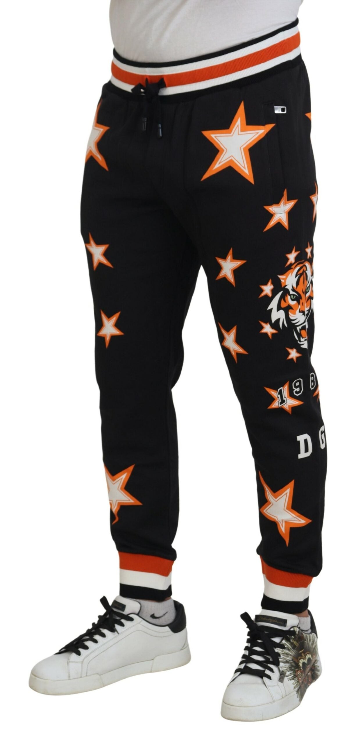 Pantalons de sport noirs et orange avec étoiles de Dolce & Gabbana, style décontracté et tendance.