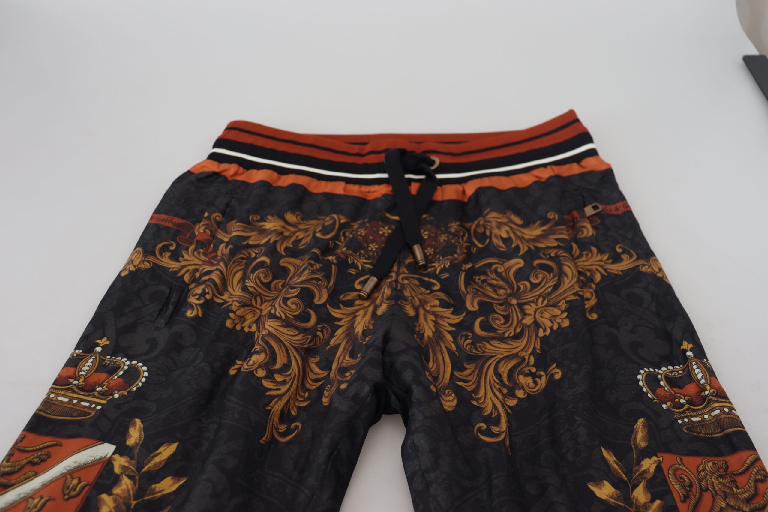 Pantalons de sport Dolce & Gabbana en soie grise à motif baroque et couronne, style élégant et sophistiqué.