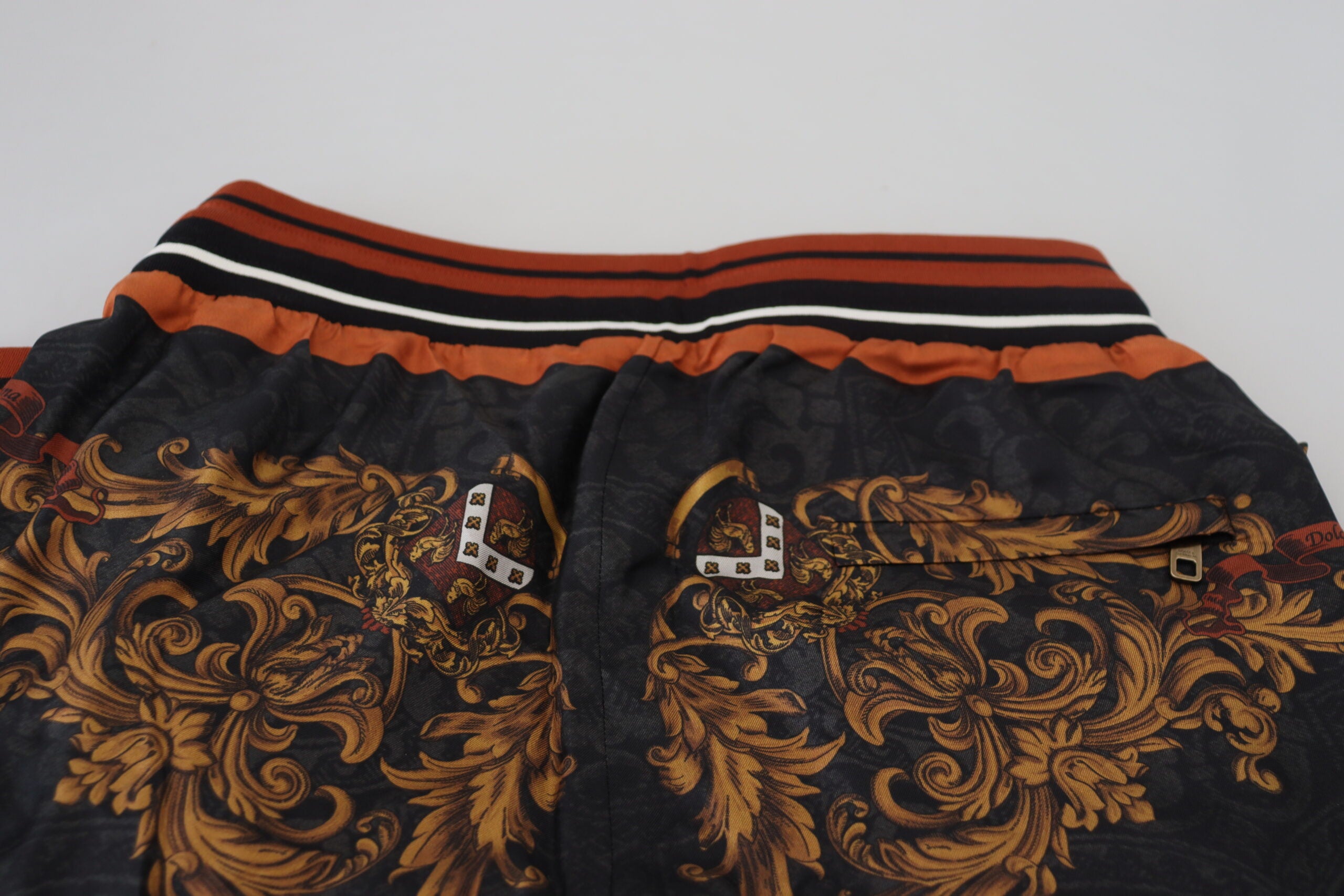 Pantalons de sport Dolce & Gabbana en soie grise avec motif baroque, style élégant et détails sophistiqués.