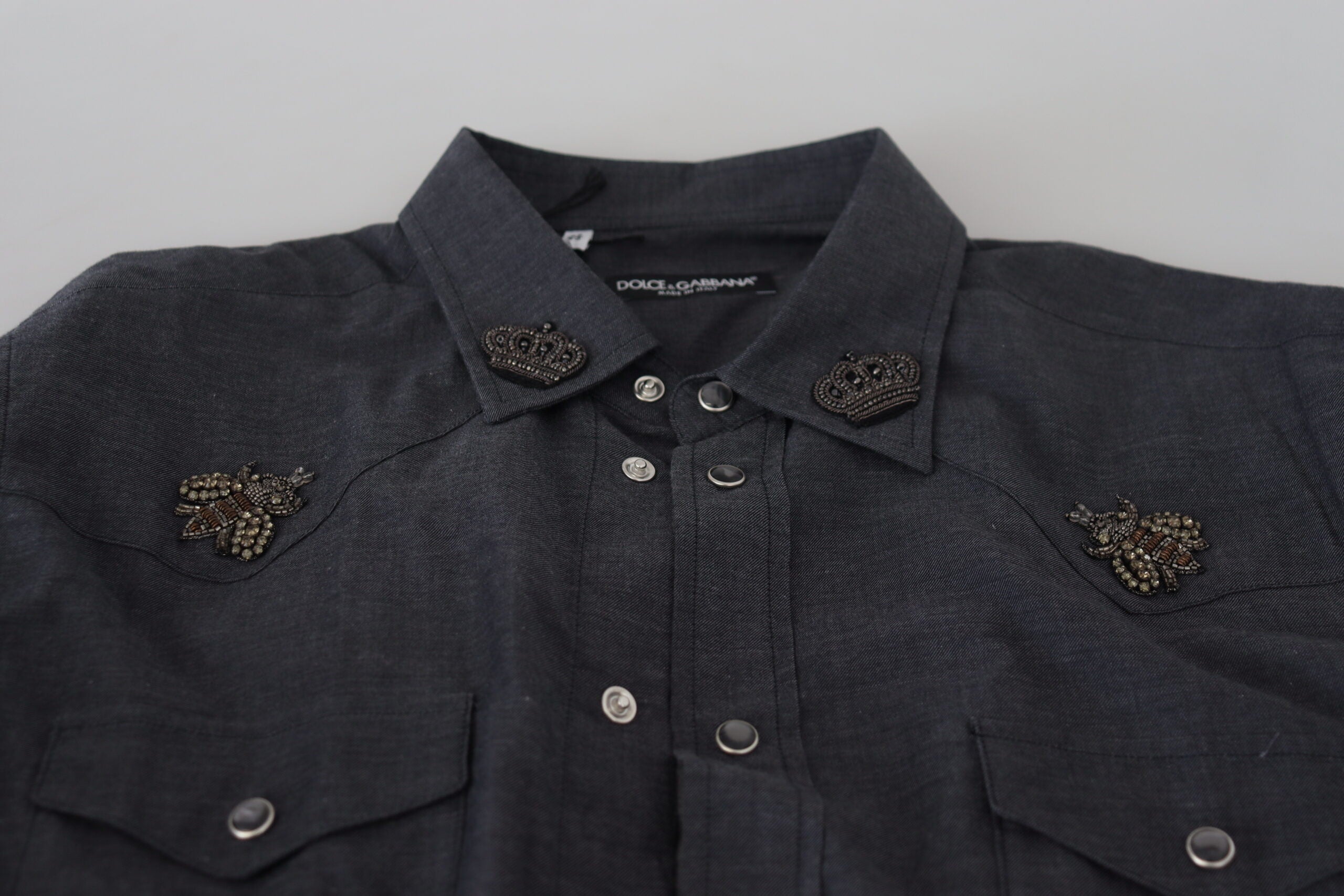 Chemise en coton denim bleu Dolce & Gabbana avec broderie abeille en cristal, style élégant et moderne.