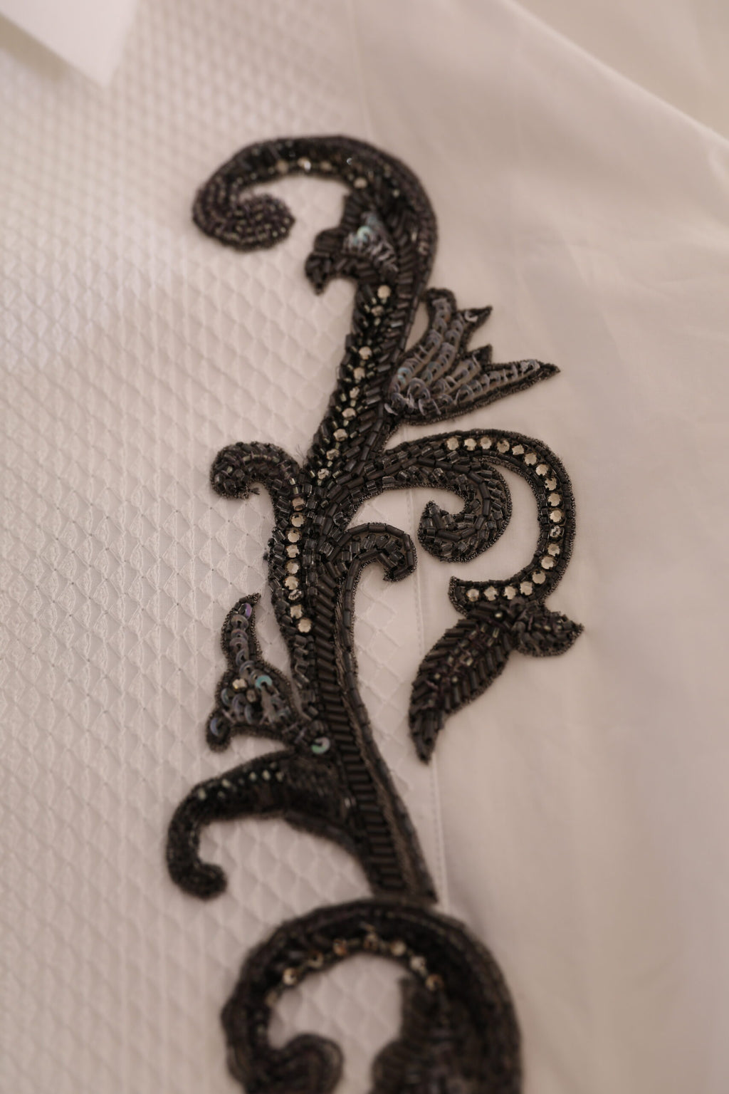Chemise blanche Dolce & Gabbana tuxedo slim fit avec motif baroque, vue en gros plan sur le tissu et les détails élégants.