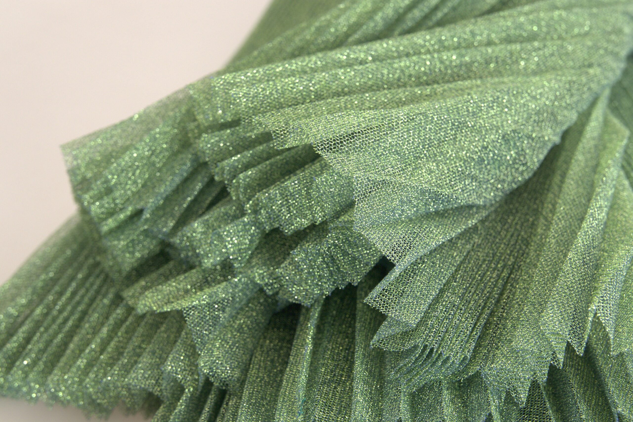 Jupe plissée vert métallisé à taille haute de Dolce & Gabbana, coupe A-line élégante, visible sur l'image.